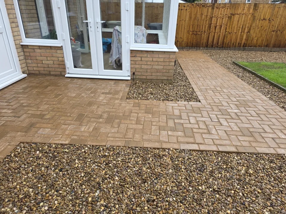Brick paving and gravel beside a conservatory